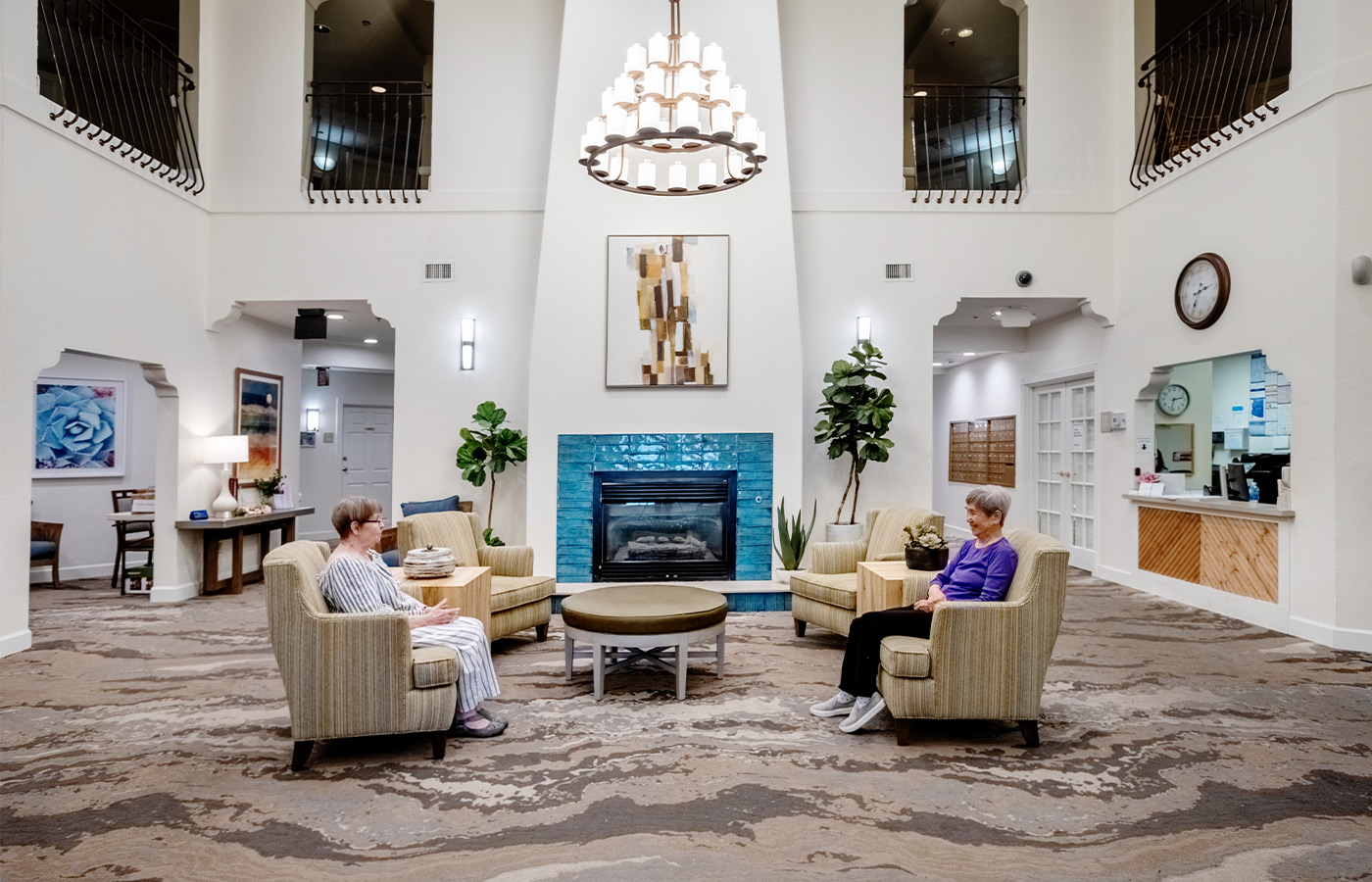 A lobby with people sitting in chairs.