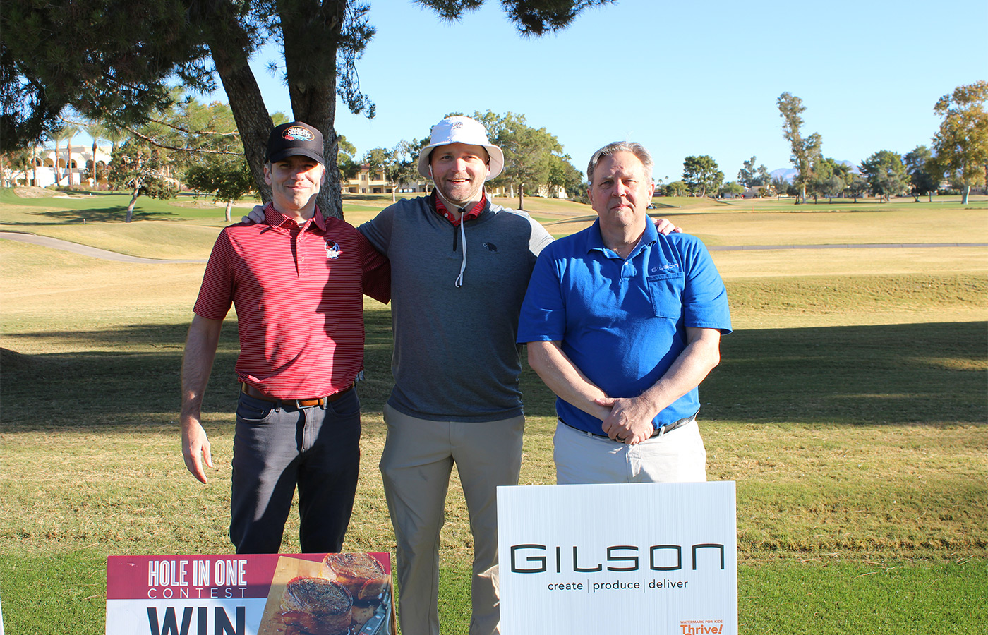 People standing on a golf course smiling.