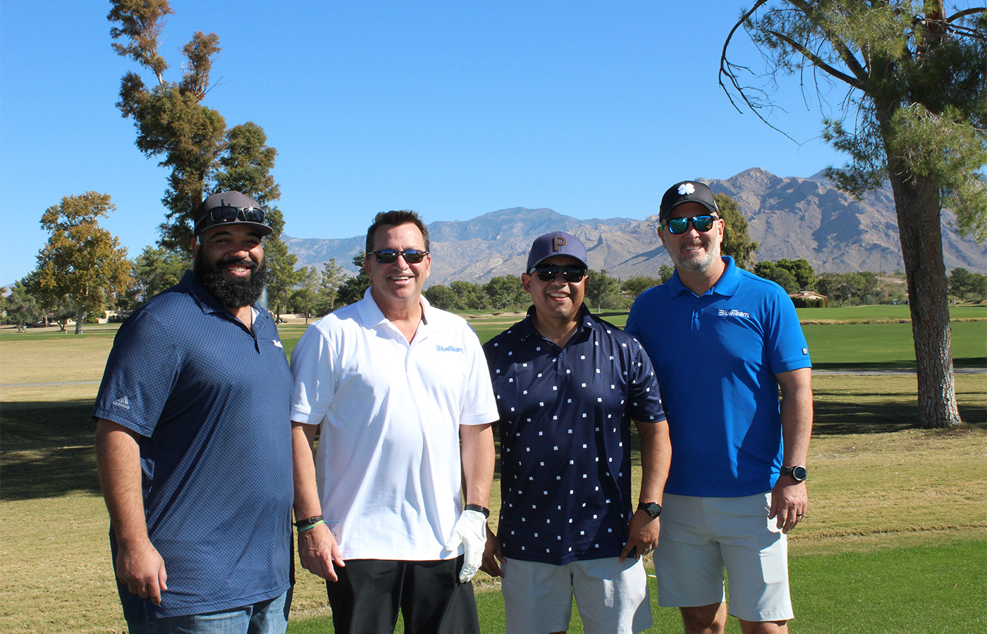 People standing on a golf course smiling.