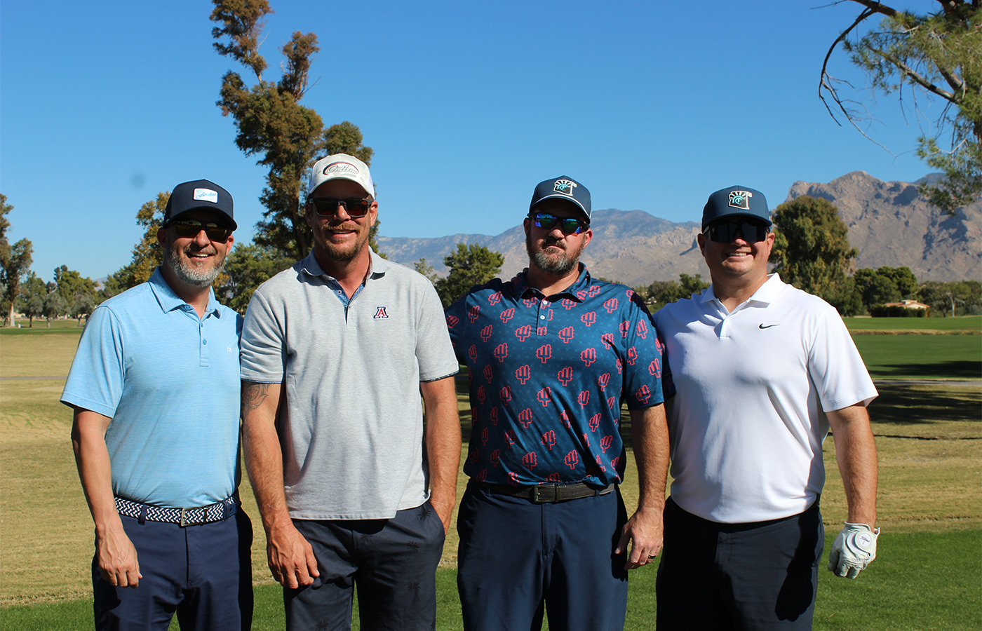 People standing on a golf course smiling.