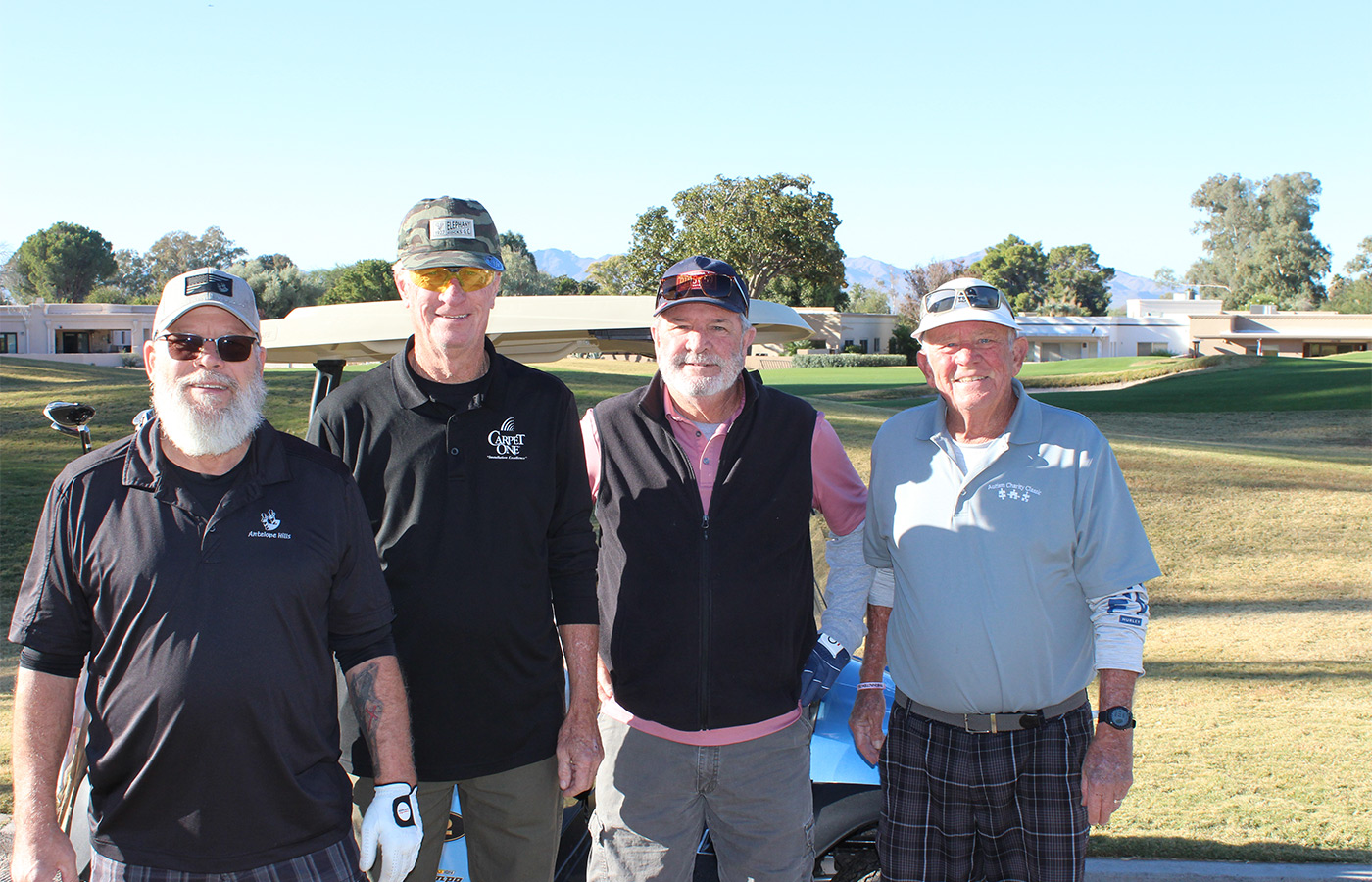 People standing on a golf course smiling.