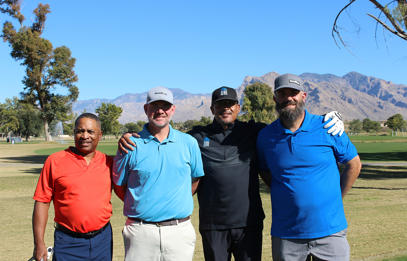 People standing on a golf course smiling.