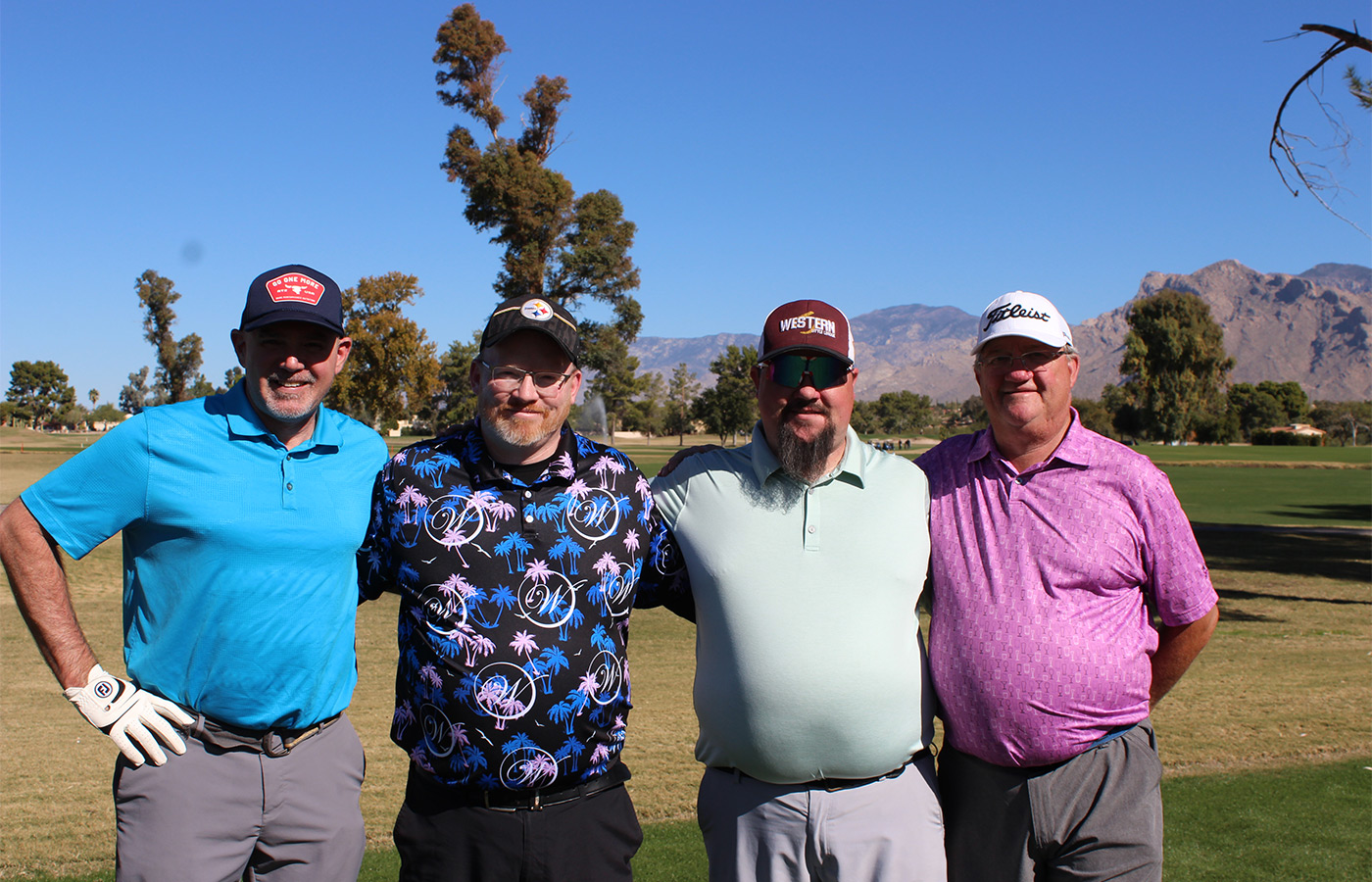 People standing on a golf course smiling.