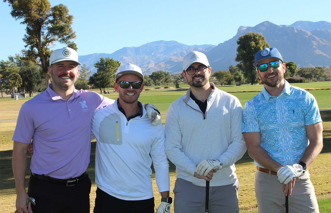 People standing on a golf course smiling.