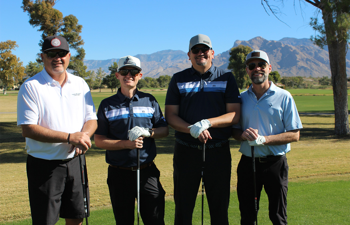 People standing on a golf course smiling.