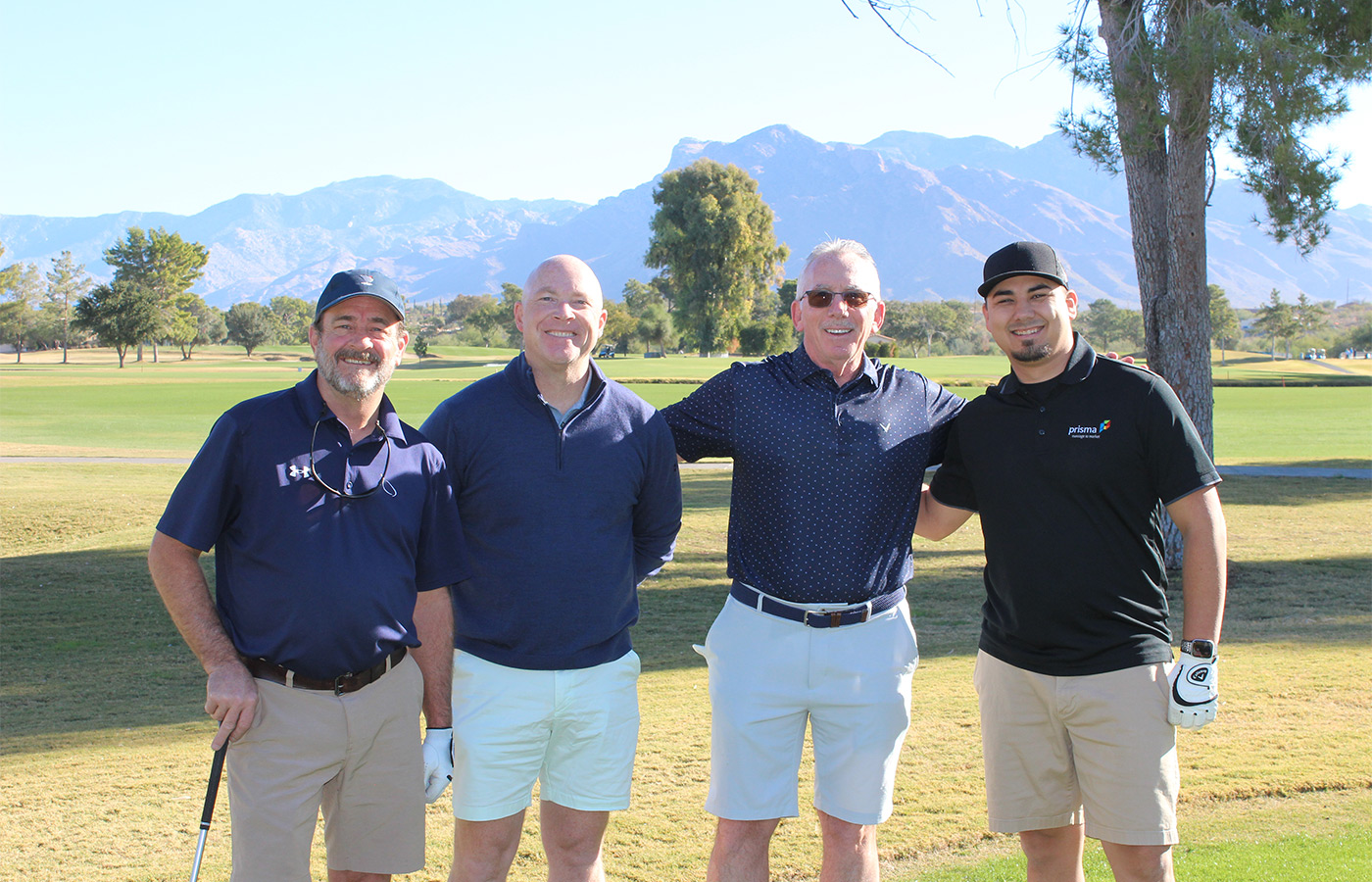 People standing on a golf course smiling.