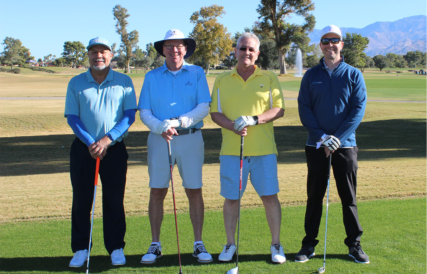 People standing on a golf course smiling.