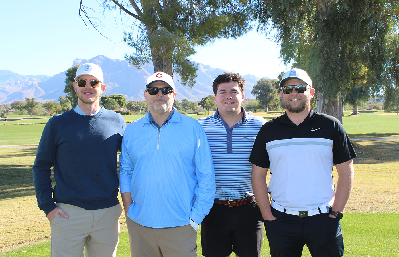 People standing on a golf course smiling.