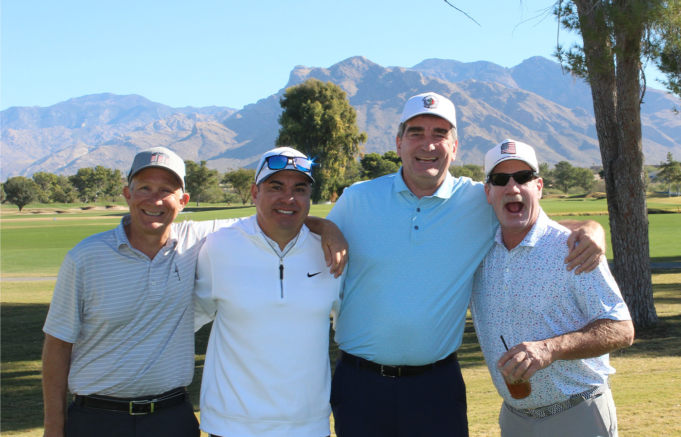 People standing on a golf course smiling.