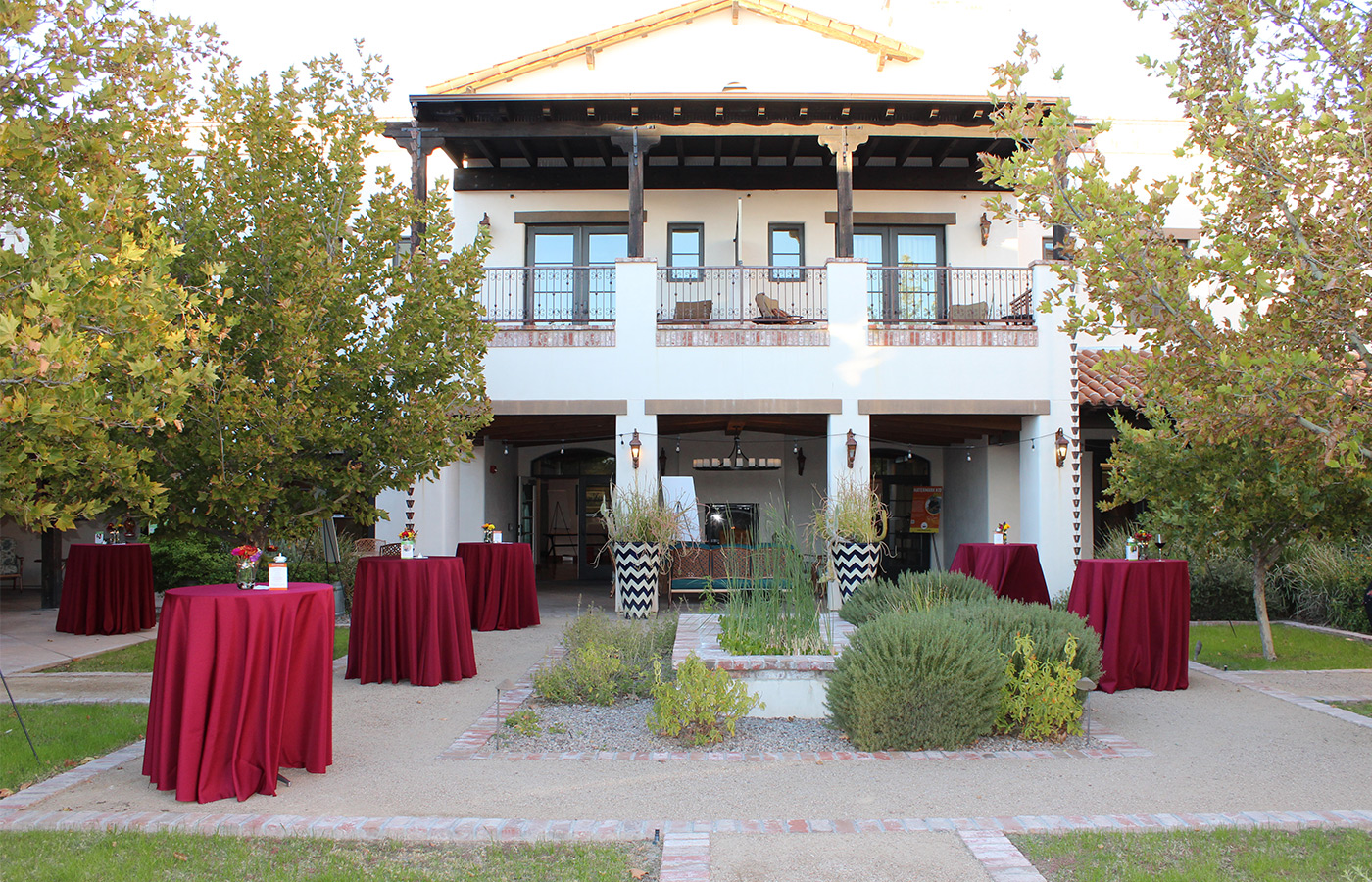 The exterior of a building with tables out front.