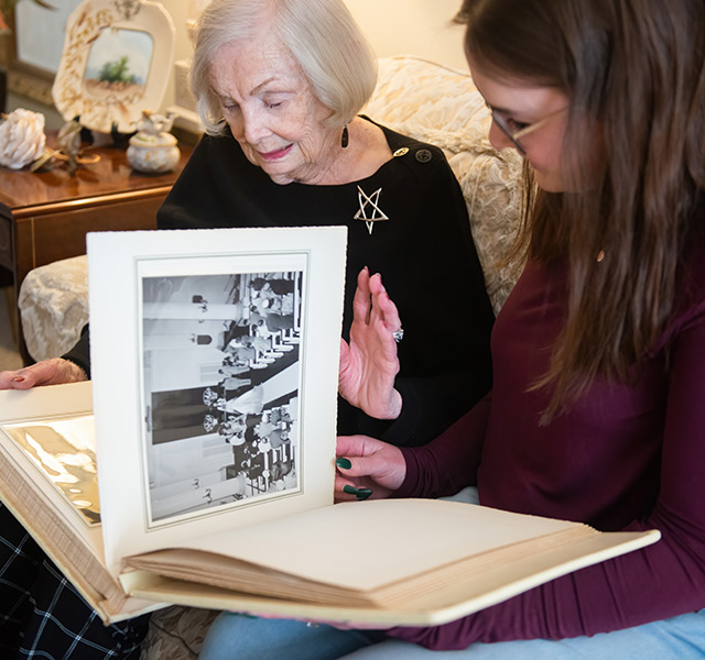 Two people looking through a photo album.