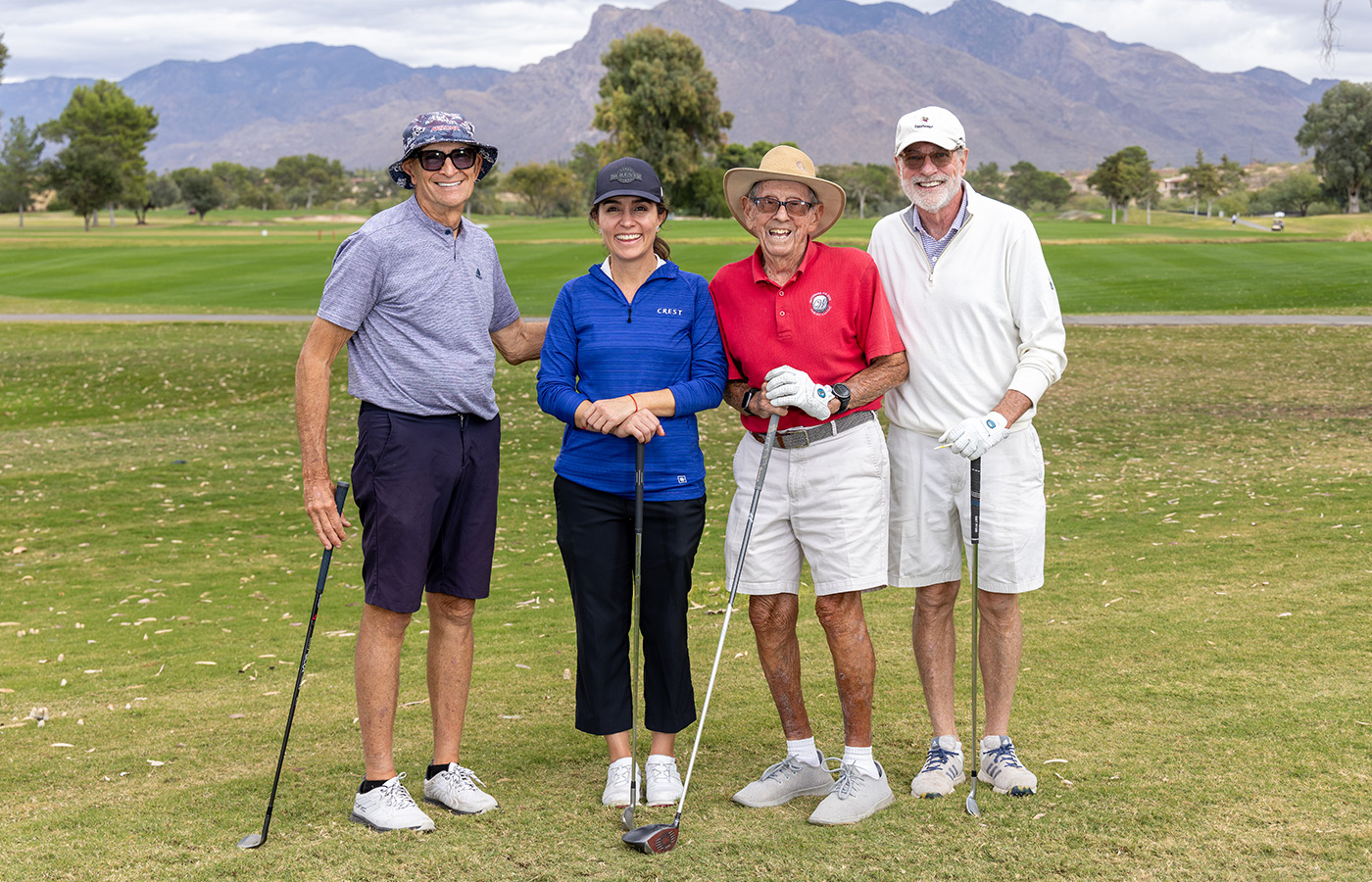 A group of people standing next to each other on the golf course.