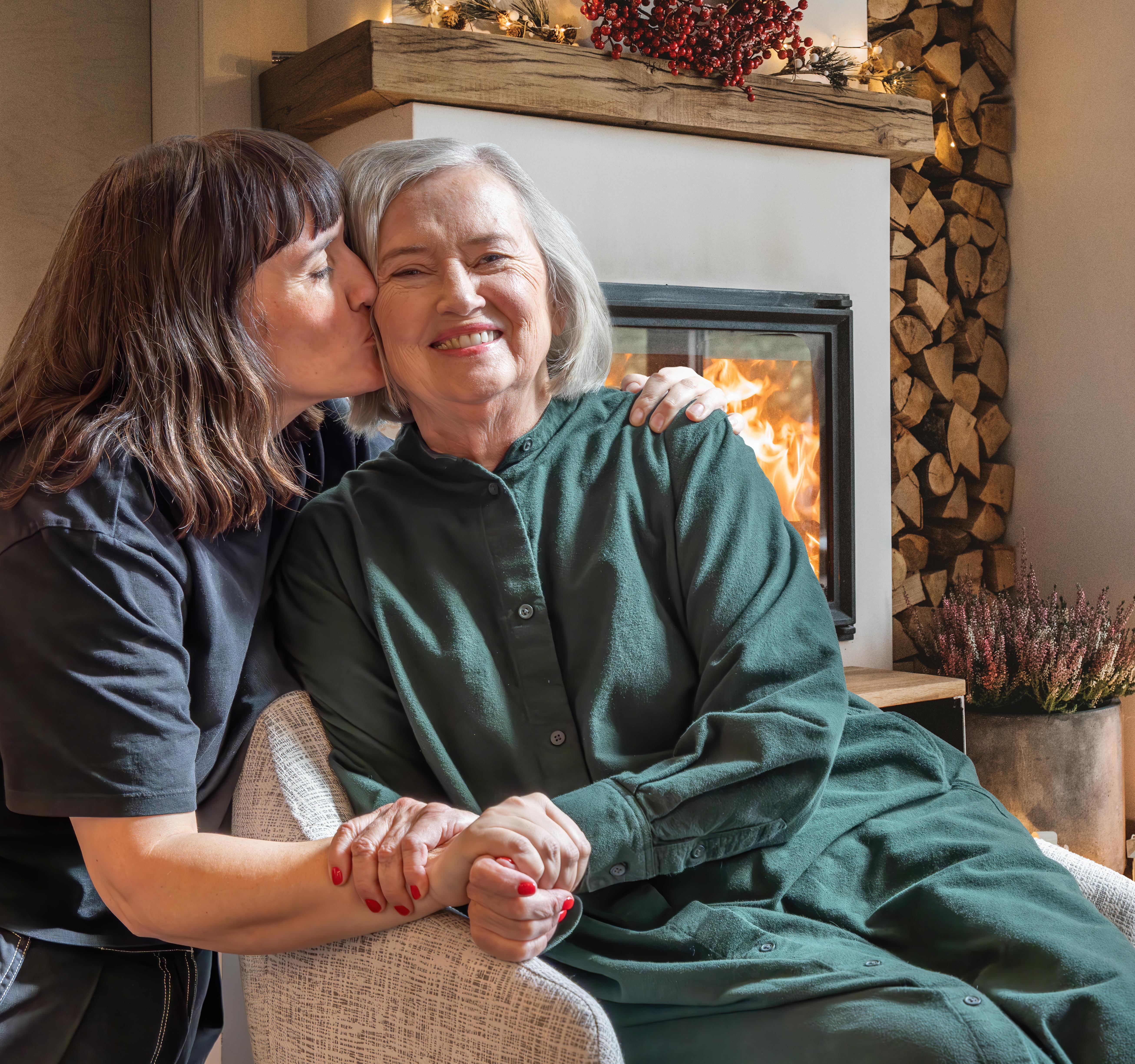 Daughter kissing mother on cheek.