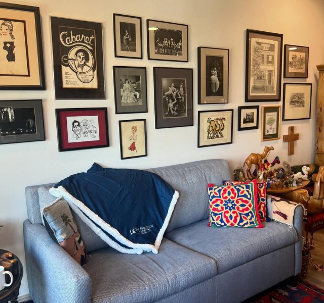 Living room with gray couch and photographs hanging on the wall.