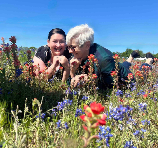 Two people laying in field of flowers