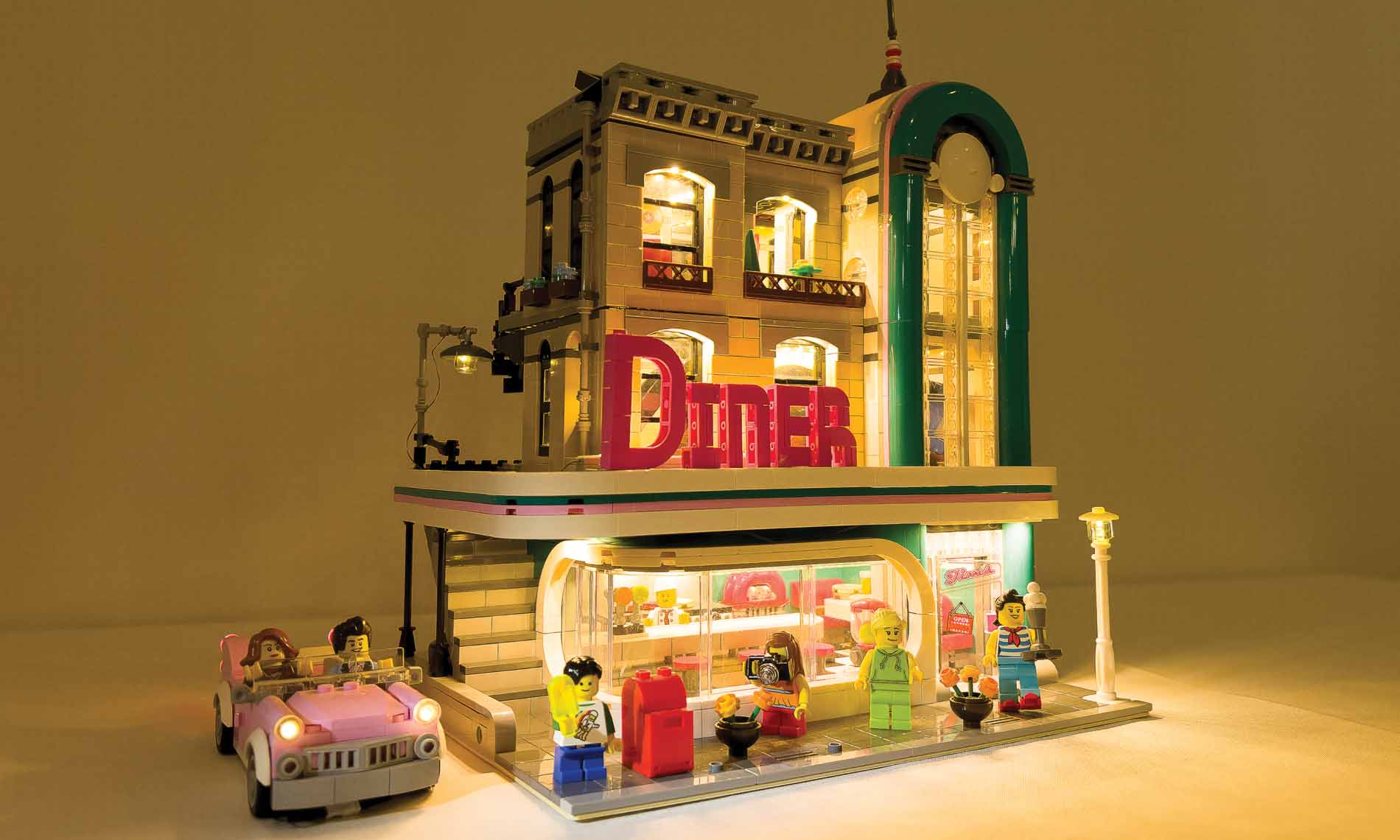 A 3-D art piece of a diner and pink vintage car.