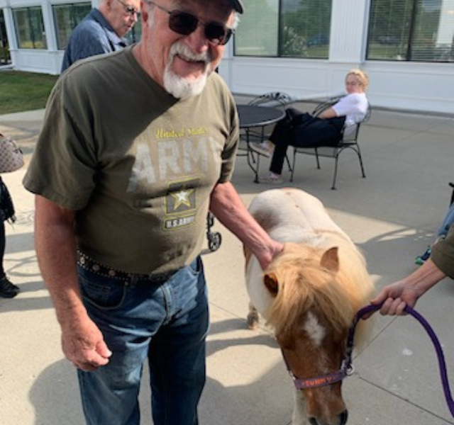 Resident petting a pony.