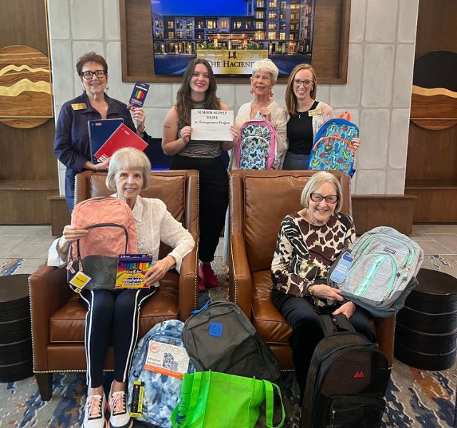 The Hacienda at Georgetown residents and associates holding up backpacks.