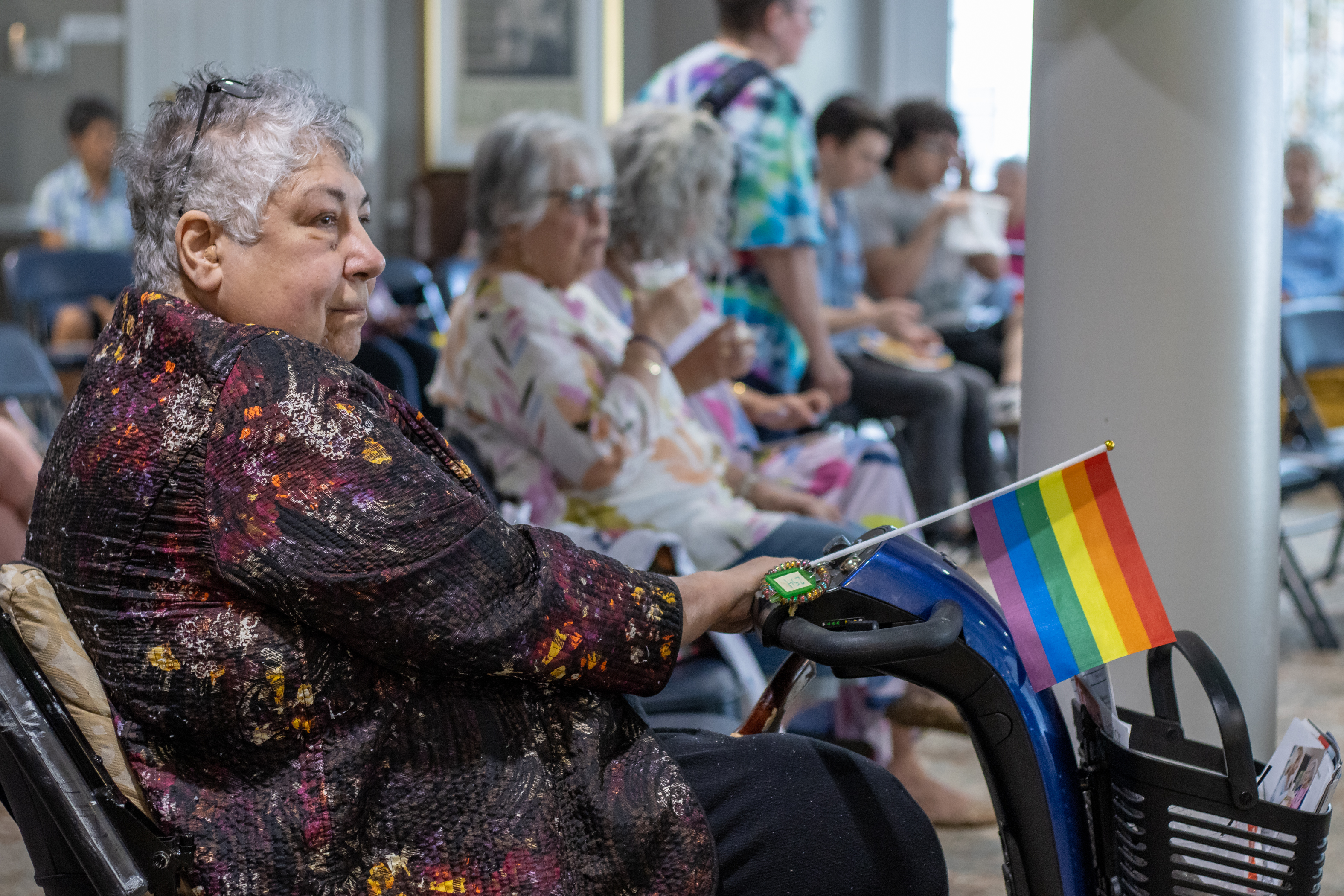 resident in wheelchair holding pride flag