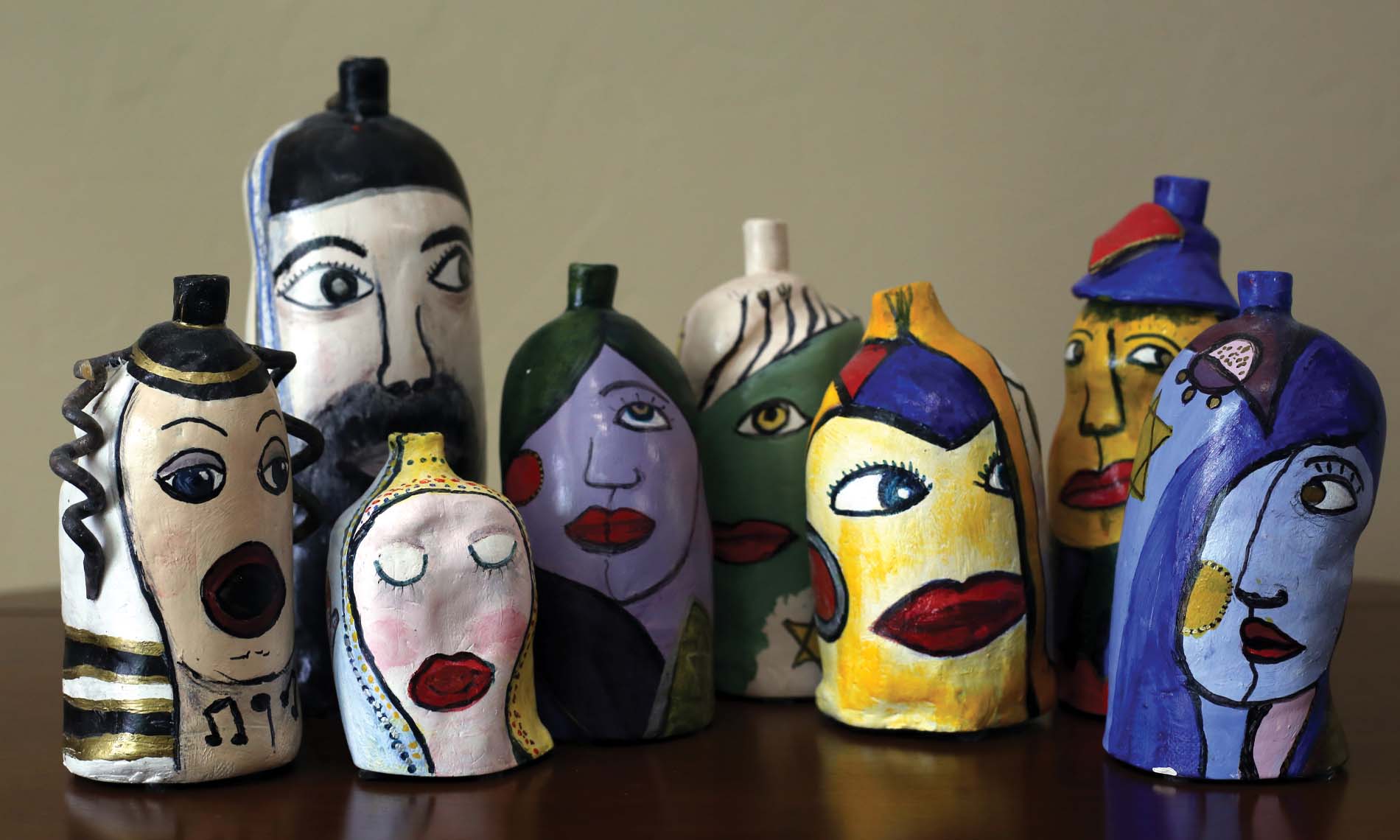 Multiple painted bottles of varying faces.