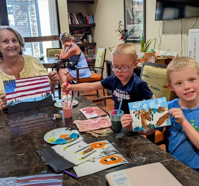 Two kids and an adult painting.