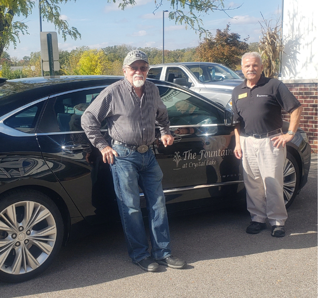 Resident and Associate by community's car.