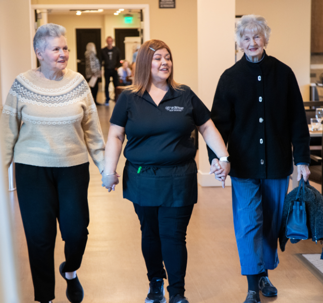 Two residents and an associate holding hands.