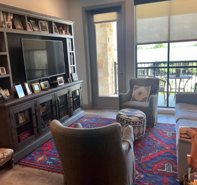 Living room with gray couch and photographs hanging on the wall.