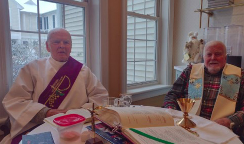 Two priests sitting down.