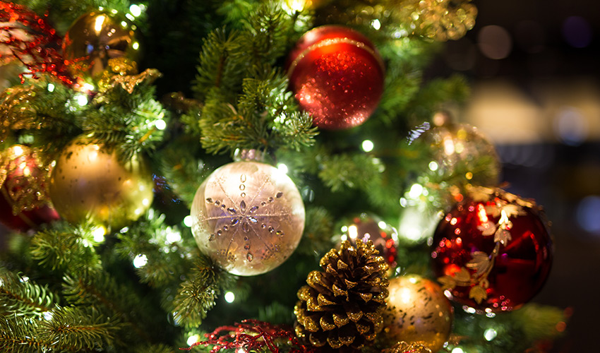 Red and gold ornaments on a christmas tree.