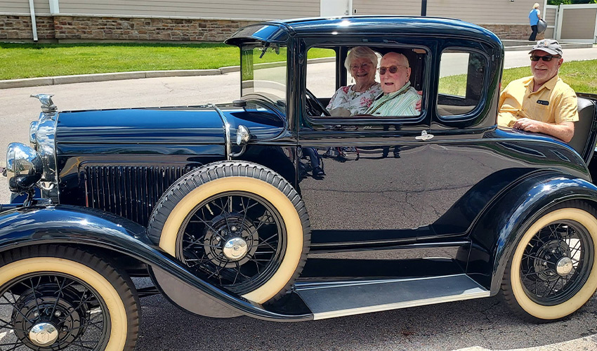 People sitting in a classic car.