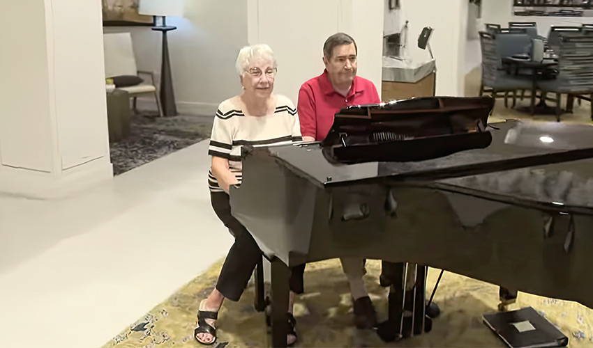 Two people sitting at a piano.