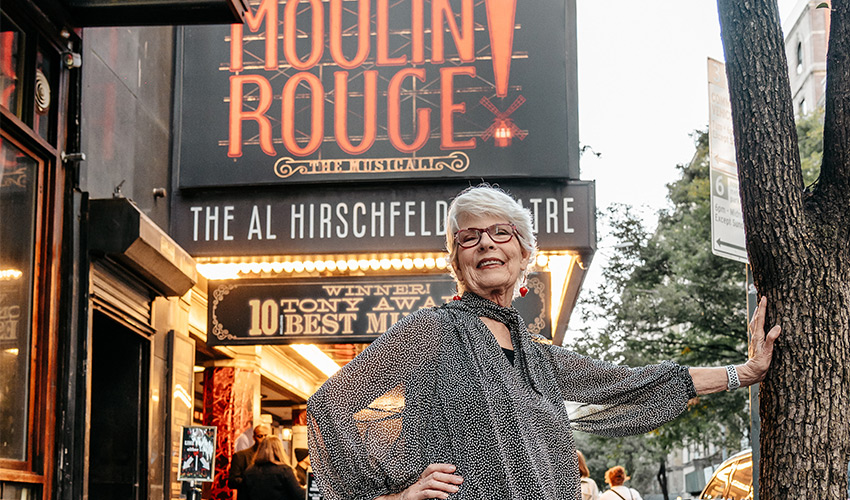 A person standing outside a theater.