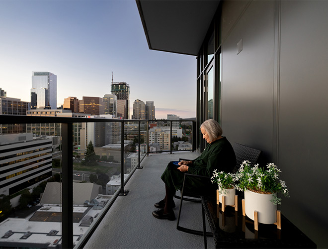 A person sitting in a chair on the balcony in the evening.