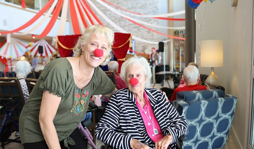 Two people with clown noses on.