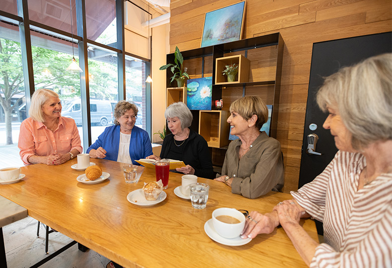 A group of people at a cafe discussing books.