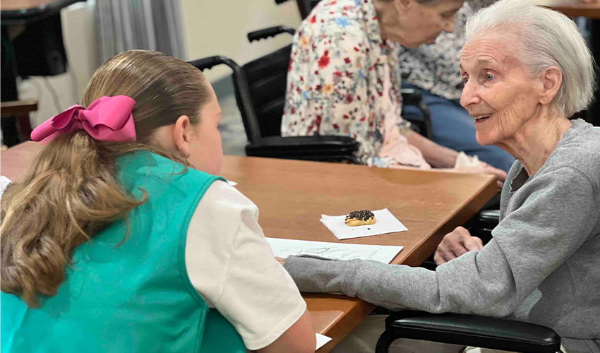 A girl scout talking to a person.