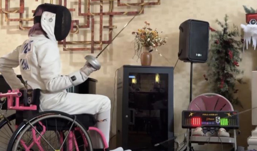 A person in a wheelchair fencing.